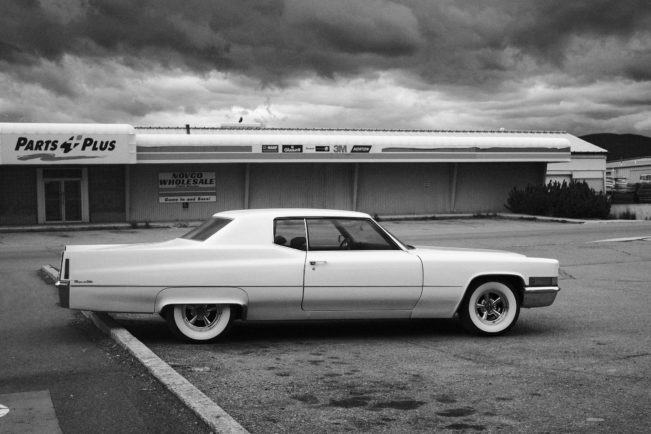 Cadillac Coupe DeVille in a Parking Lot in Front of an Auto Part Store